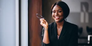Confident professional woman in business attire holding glasses — marketing resume example