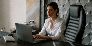 Smiling professional updating resume on laptop — Breathe New Life Into Your Resume for 2025