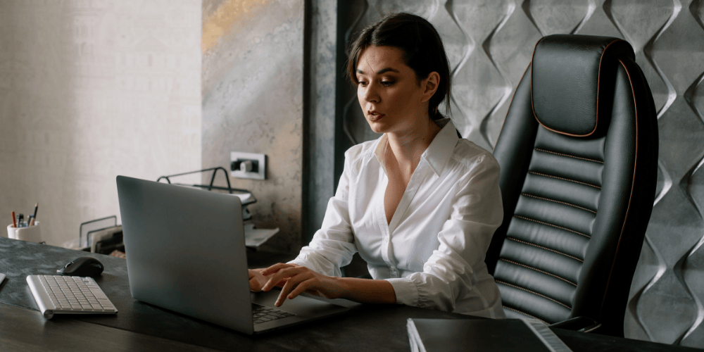 Smiling professional updating resume on laptop — Breathe New Life Into Your Resume for 2025