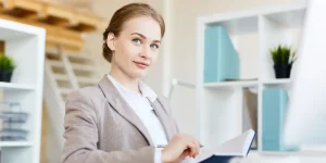 Professional writing resume on laptop with notepad — Tips for Writing a Winning Resume That Gets You Hired