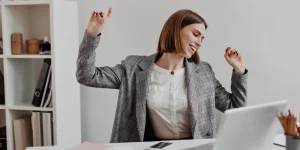 Excited professional woman celebrating success at a laptop — identify your unique value proposition before applying for a job