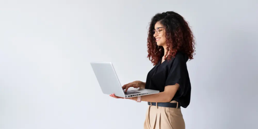 Confident woman holding a laptop showcasing professional skills — how to demonstrate transferable skills on a resume