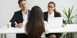 Job candidate in an interview meeting with two professionals — write a compelling cover letter for your job application