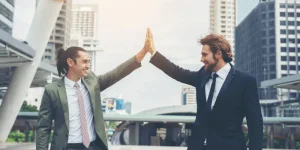 Two professionals high-fiving outdoors in front of city buildings — how to write a resume for the healthcare industry