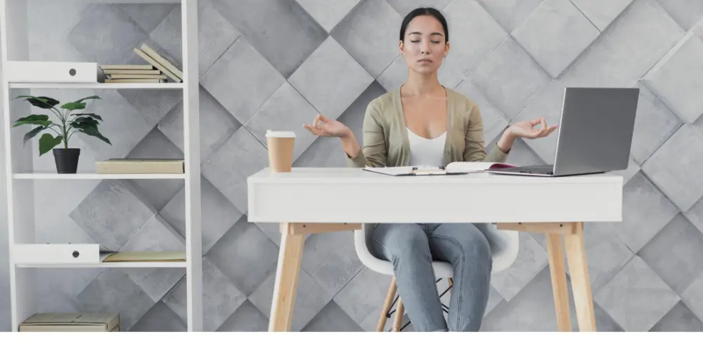 Woman meditating at her desk with laptop in a calm home office — career growth tips that support a balanced life