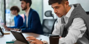 IT professionals working at laptops in a modern office — how US IT jobs are getting impacted by AI