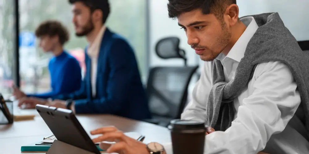 IT professionals working at laptops in a modern office — how US IT jobs are getting impacted by AI