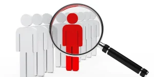 Red figure standing out from a crowd under a magnifying glass — how to make a strong resume that stands out to employers