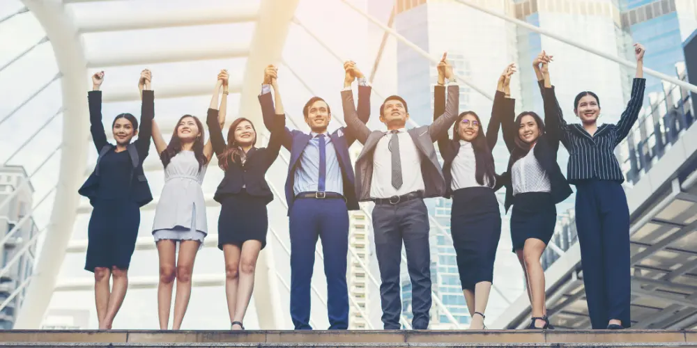 Diverse group of professionals celebrating a career change — avoid these resume mistakes when changing careers