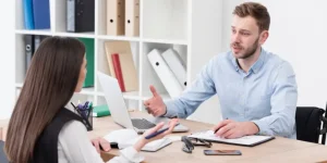 A human resume writer consulting with a job seeker at a desk, helping craft a professional resume in the age of AI