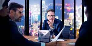 Professionals in a business meeting with city skyline at night — how to succeed in your job search during a global conflict