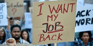 Protesters holding signs including I Want My Job Back - US jobless claims rising as labor market softness grows